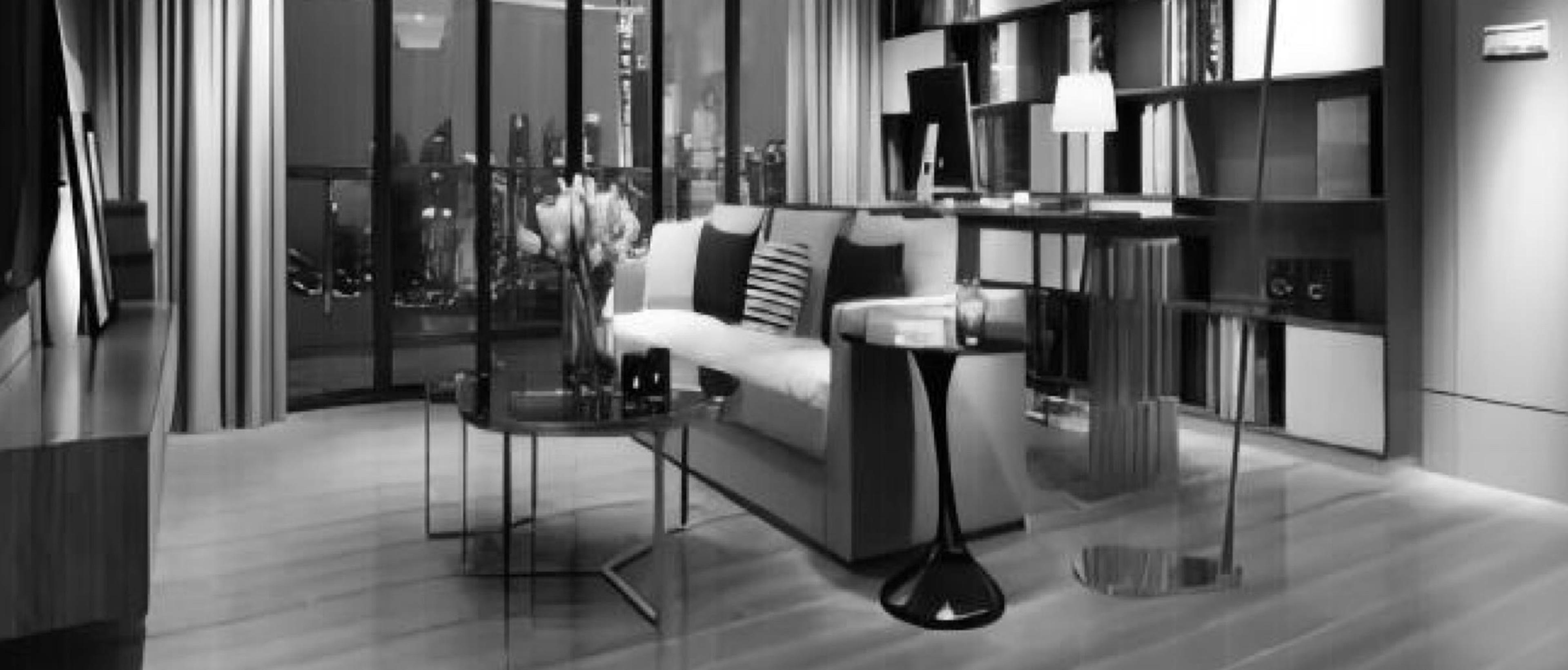 Living con piso de porcelanato símil madera en tablas largas, sillón claro y biblioteca