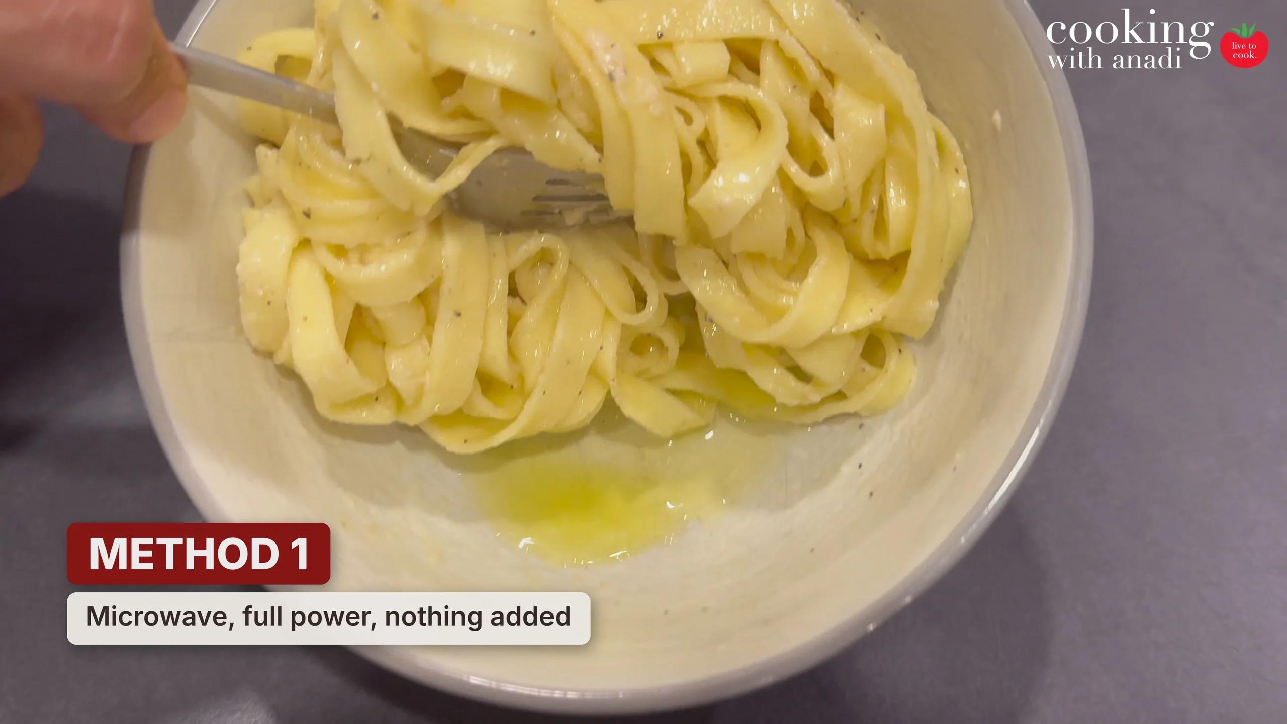 Leftover fettuccine alfredo microwaved at full power, with a pool of separated oil in the bottom of the bowl