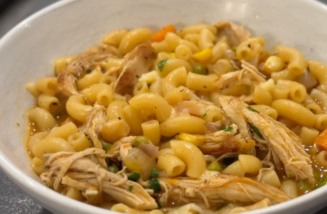 One-pot Tex Mex chicken noodle soup with shredded chicken, elbow pasta, and corn in a white bowl.
