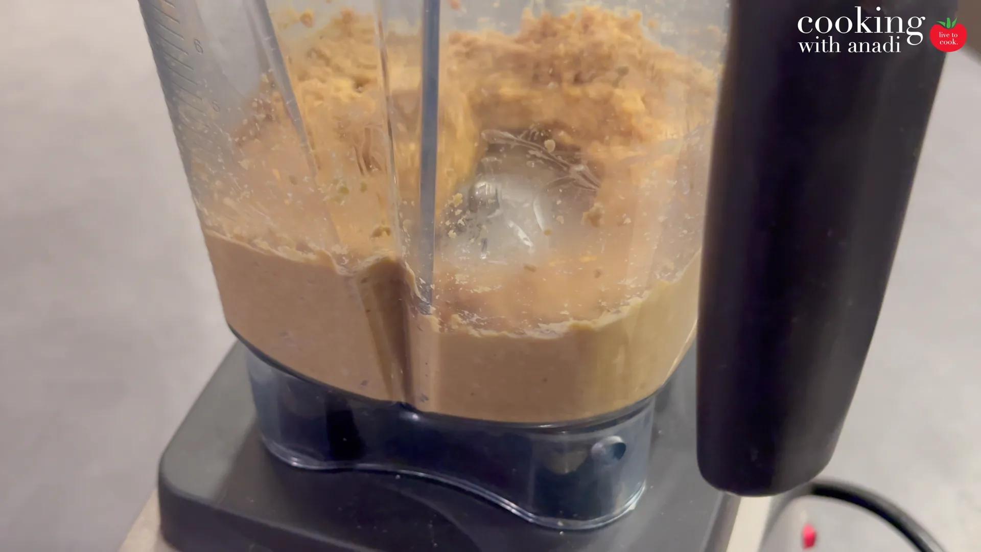 Peanuts turning into smooth peanut butter around the blades of the Vitamix