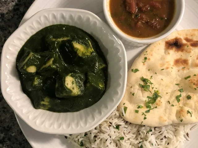 Instant Pot Palak Paneer served with basmati rice, naan bread, and brown sauce on the side.