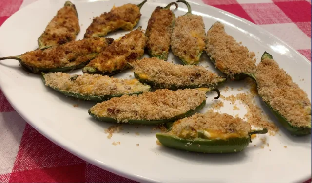 Plate of golden-brown breaded jalapeño poppers with melted cheese visible inside the halved peppers.