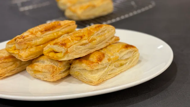 Golden-brown chicken keema puff pastry patties arranged on a white plate.