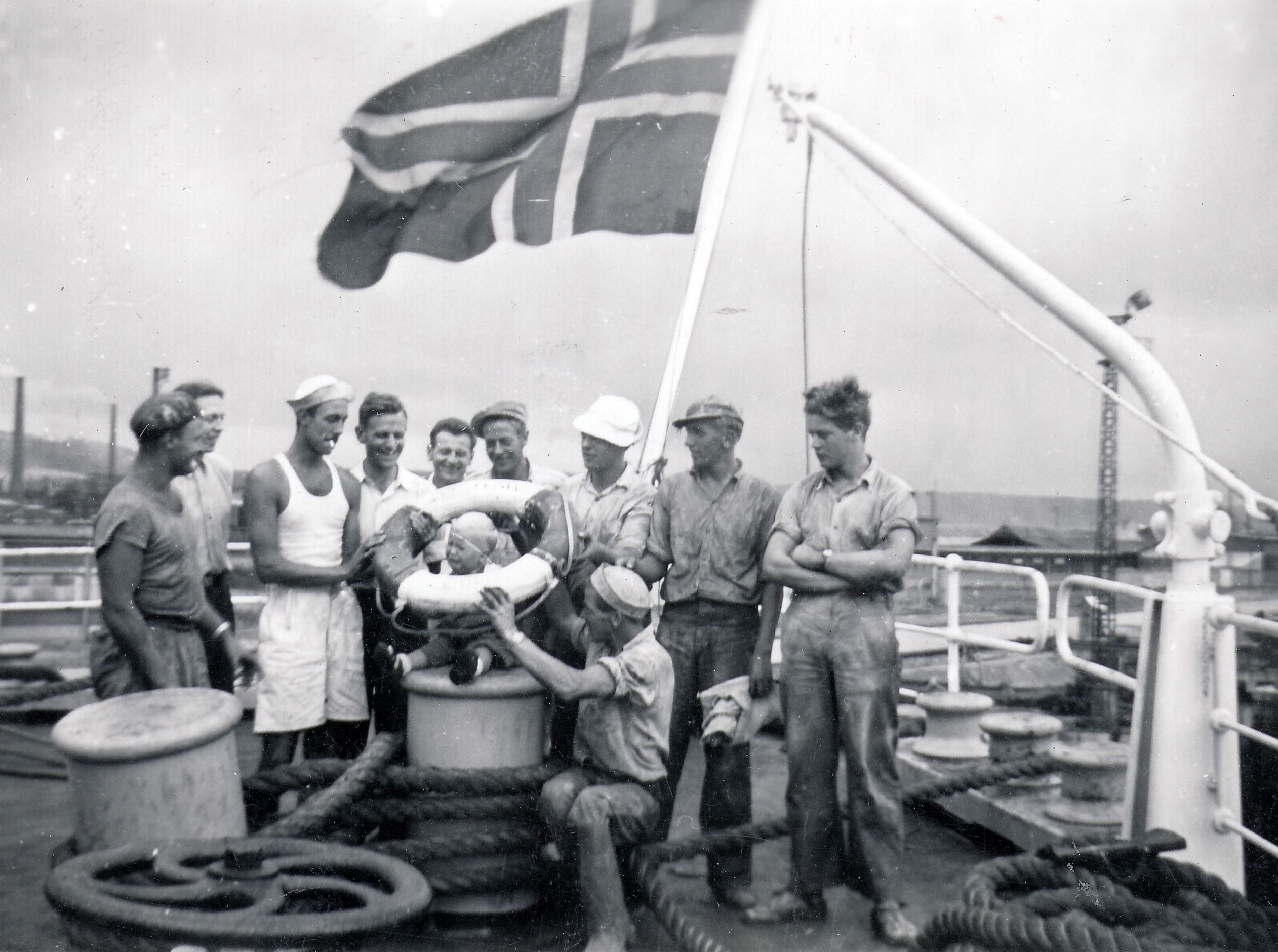 A black and white photo of Norwegian sailors and a baby