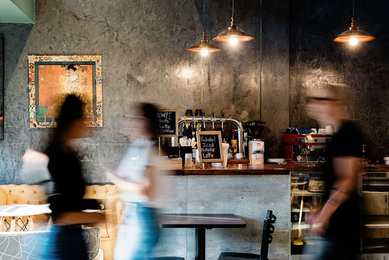 Cozy café with blurred people walking by.