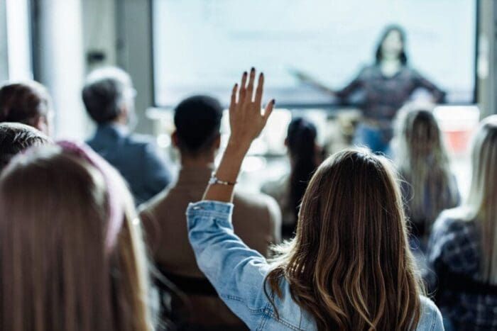 Audience member raising hand at a business seminar