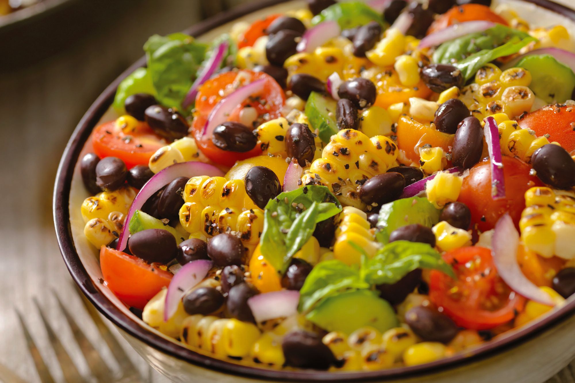 A bowl of black bean, grilled corn and tomato salad made with Doudlah Farms organic ingredients