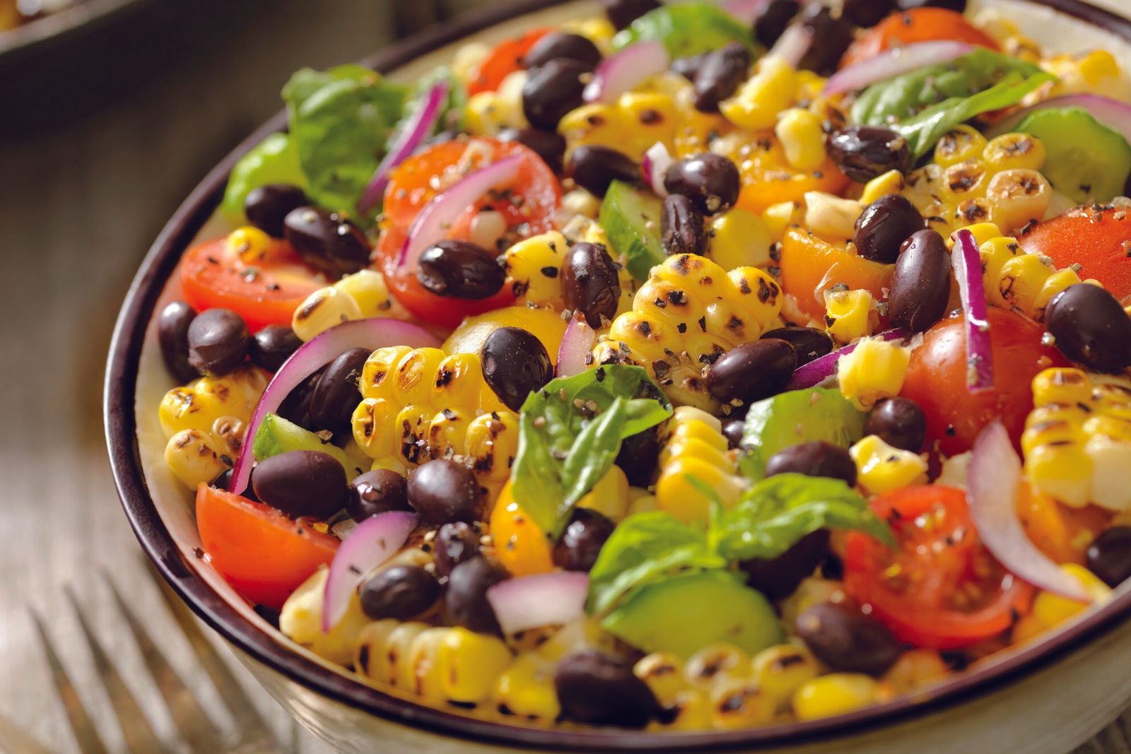 A bowl of black bean, grilled corn and tomato salad made with Doudlah Farms organic ingredients