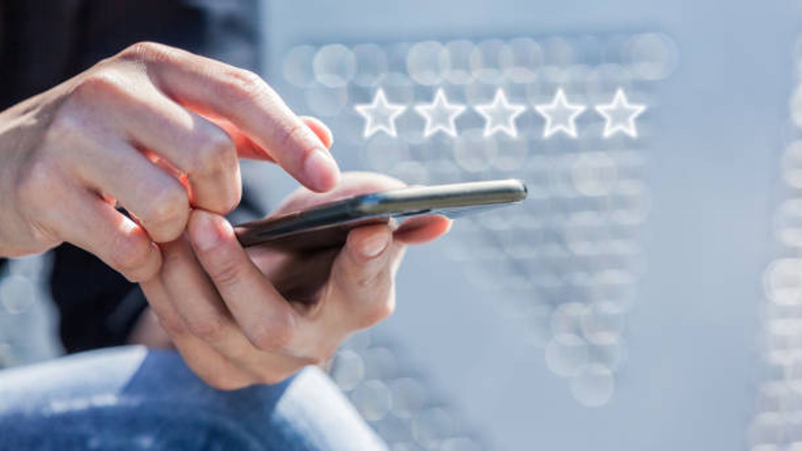 Person using smartphone with five-star review icons