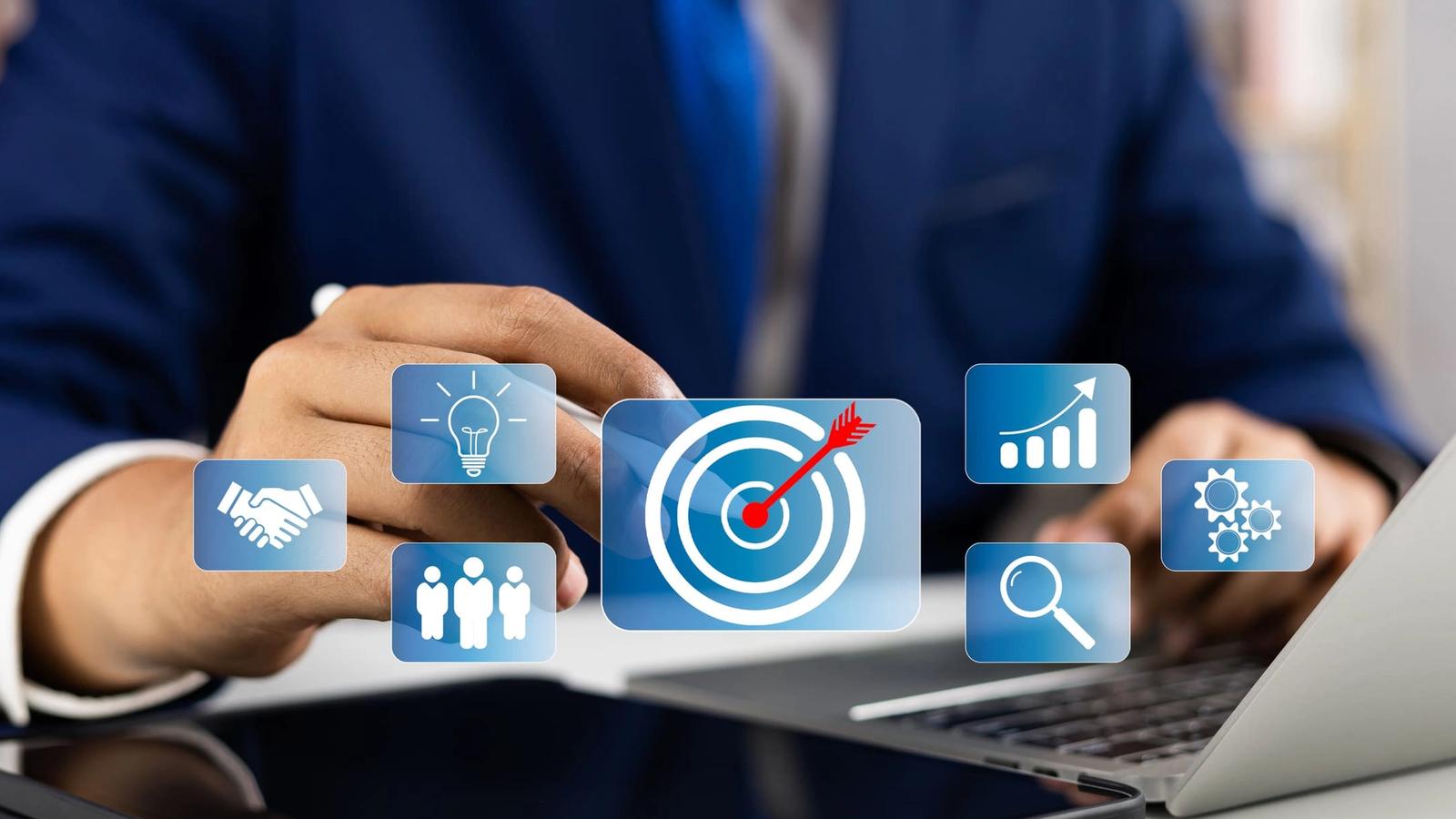 A person in a suit touches a virtual icon of a target with an arrow, symbolizing a goal. Other icons, representing Product Market Development (PMD), include a handshake, lightbulb, group of people, bar chart, and magnifying glass—denoting ideas, teamwork, success metrics, and search/research.