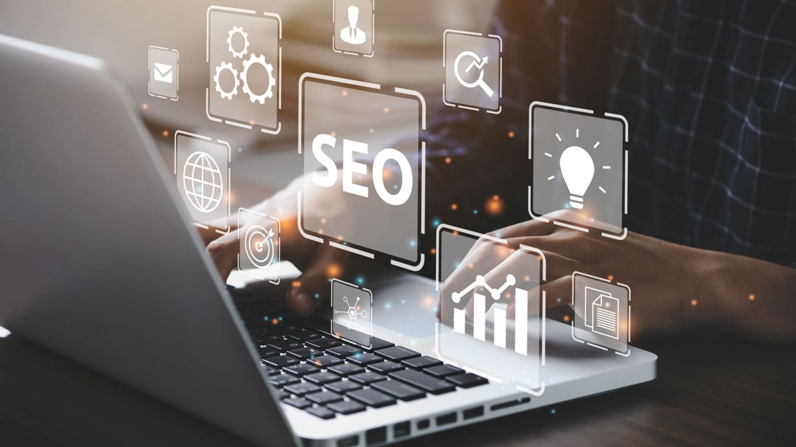 A person types on a laptop with overlays of various icons related to digital marketing and SEO, such as gears, a lightbulb, and a bar graph. The large central icon reads "SEO," emphasizing search engine optimization and competitor site analysis. The scene is backlit with soft lighting.