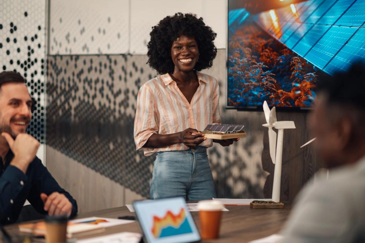 Woman presenting solar panel model in meeting