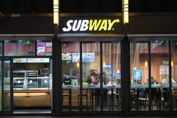 Nighttime view of busy Subway restaurant interior