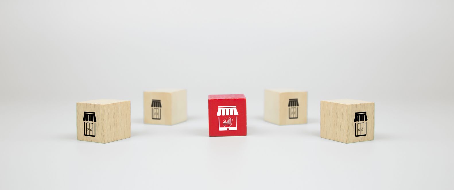 Wooden blocks with store icons, one red online.