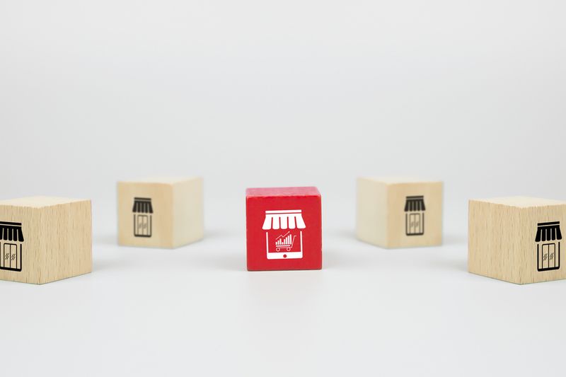 Wooden blocks with store icons, one red online.
