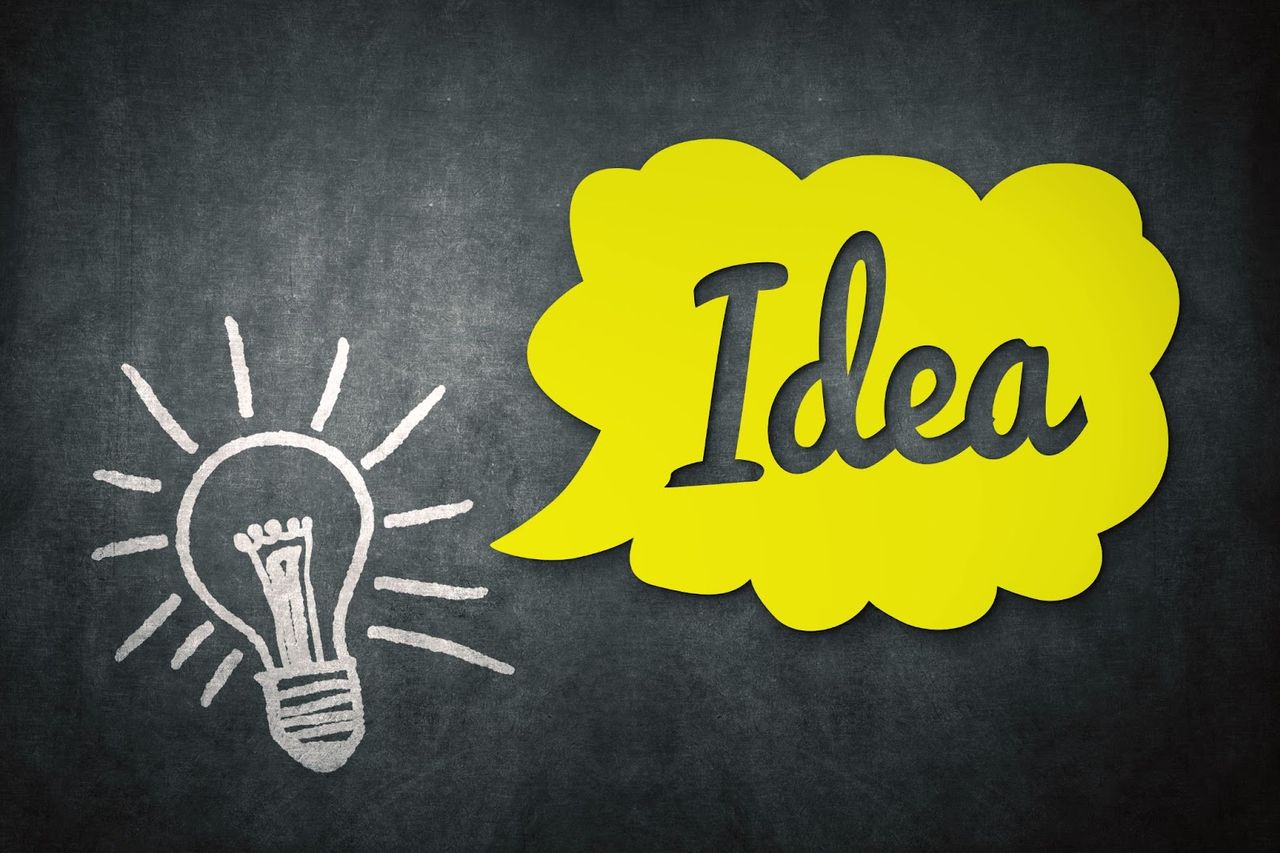 Chalk lightbulb and yellow idea bubble on blackboard.