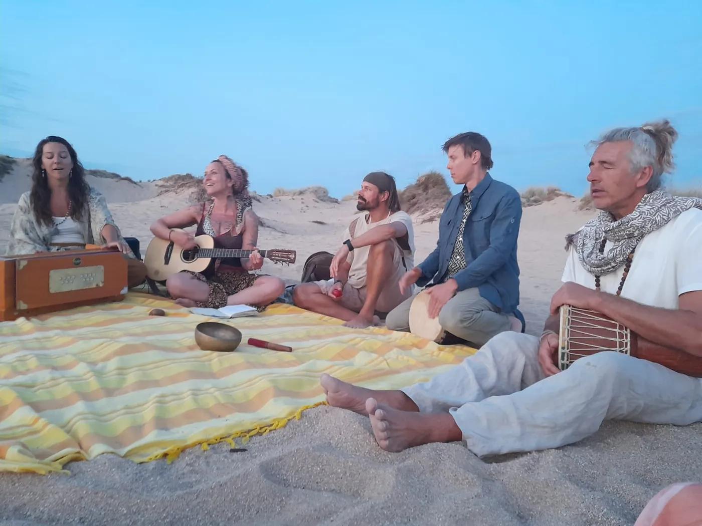 Kirtan-Kreis am Strand in der Abenddämmerung