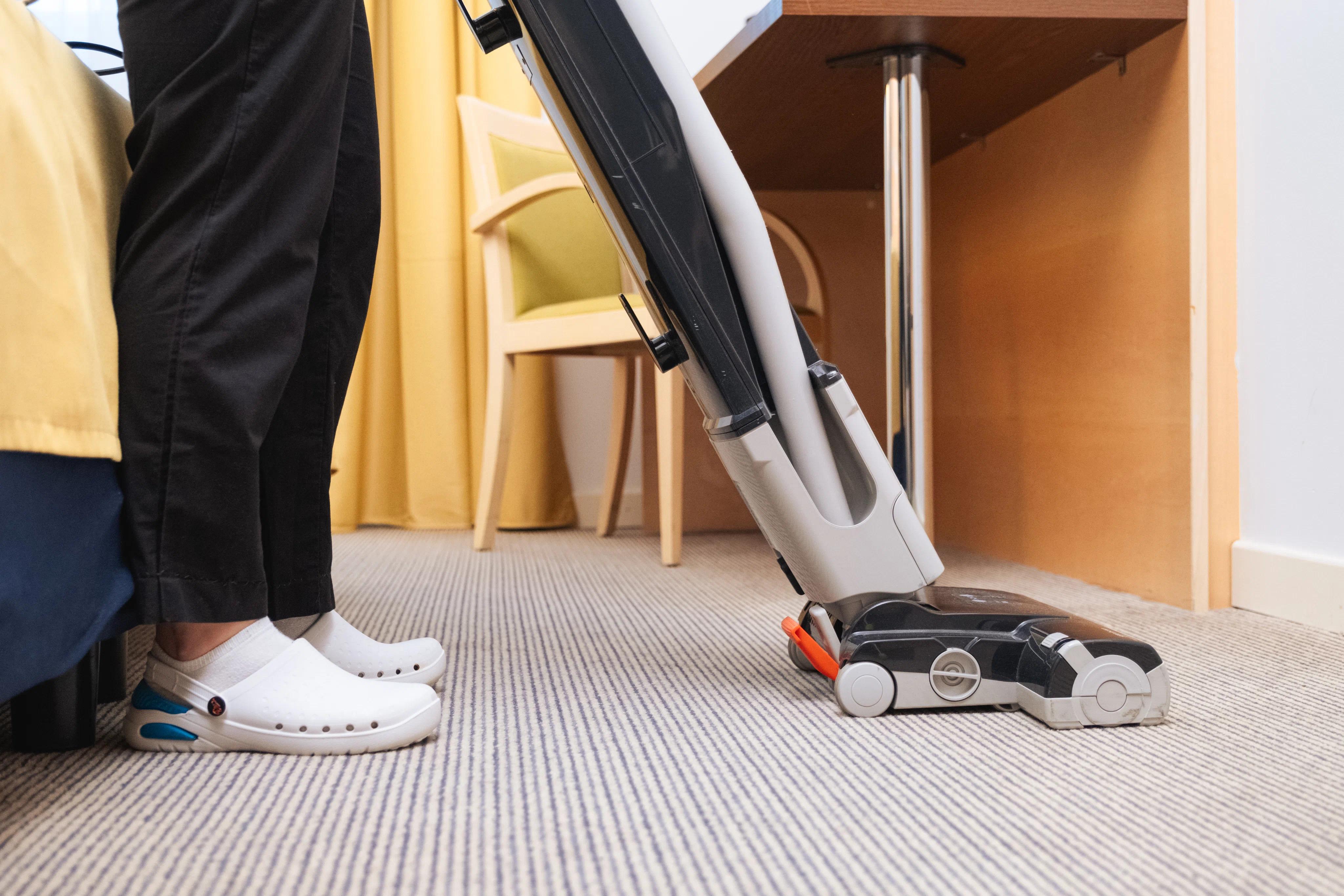 una persona che pulisce con un'aspirapolvere