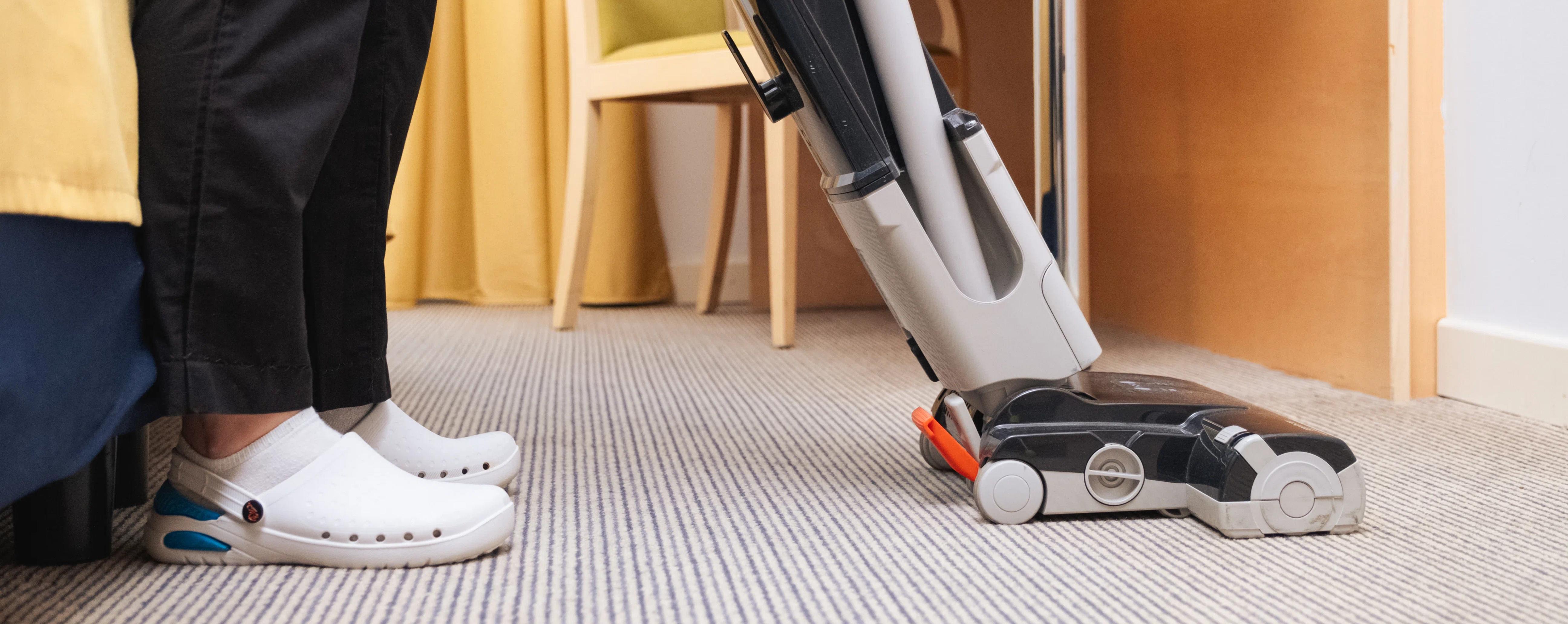 una persona che pulisce con un'aspirapolvere