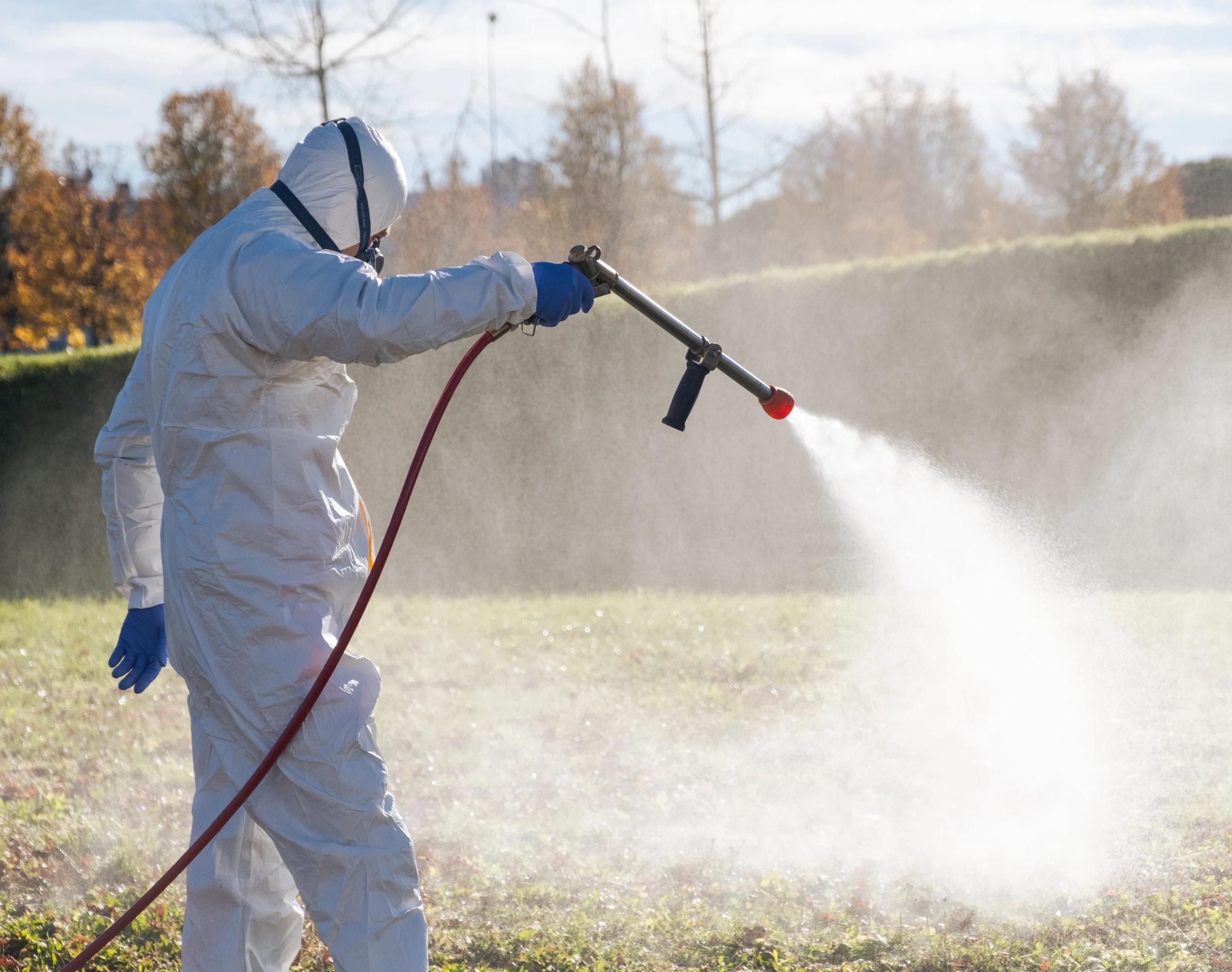 una persona che indossa una tuta bianca e spruzza dell'acqua