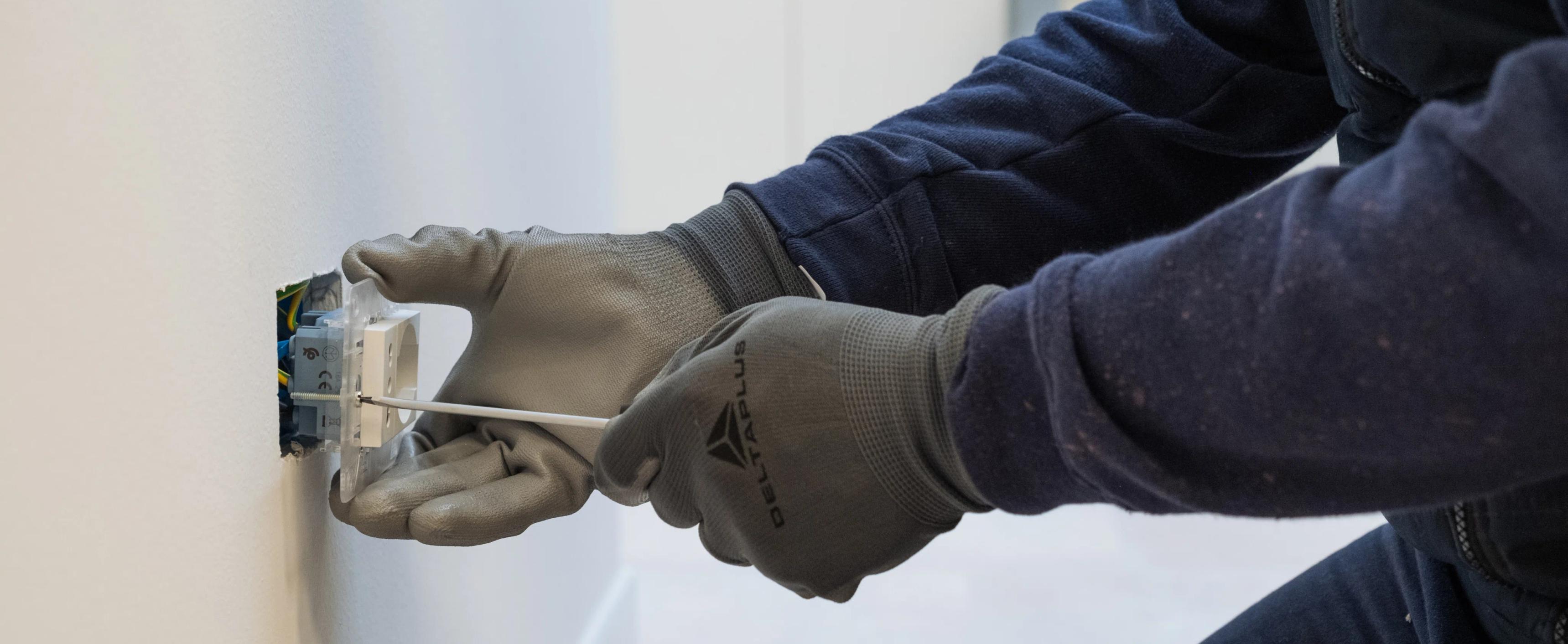 una persona che ripara una presa elettrica