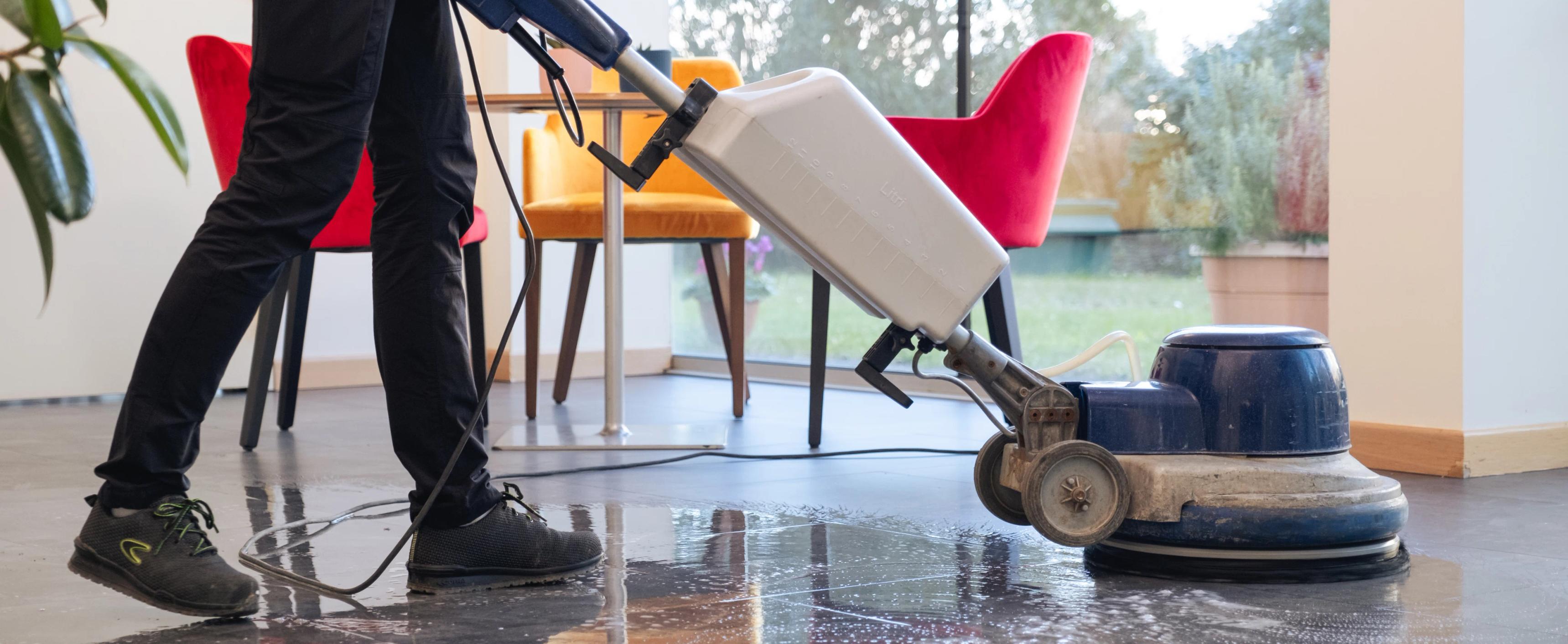 una persona che pulisce con un'aspirapolvere
