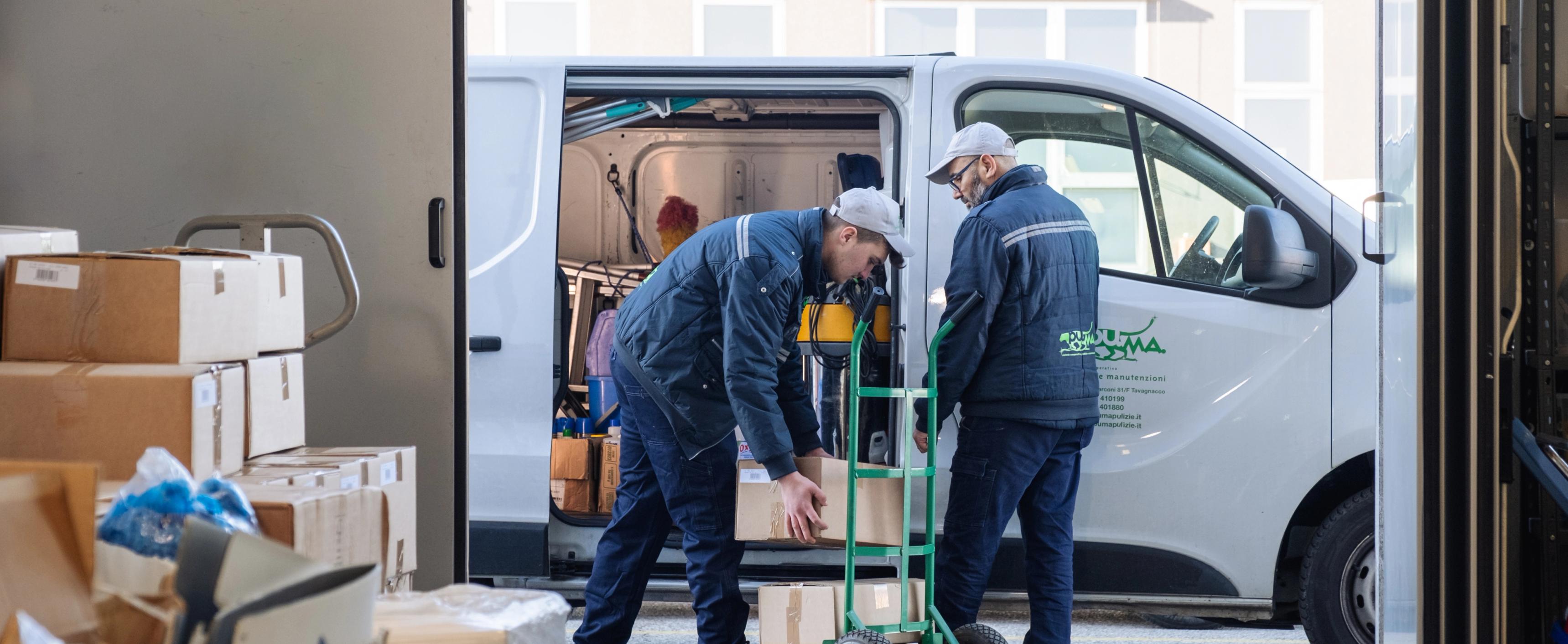 due persone che scaricano dei pacchi da un furgone