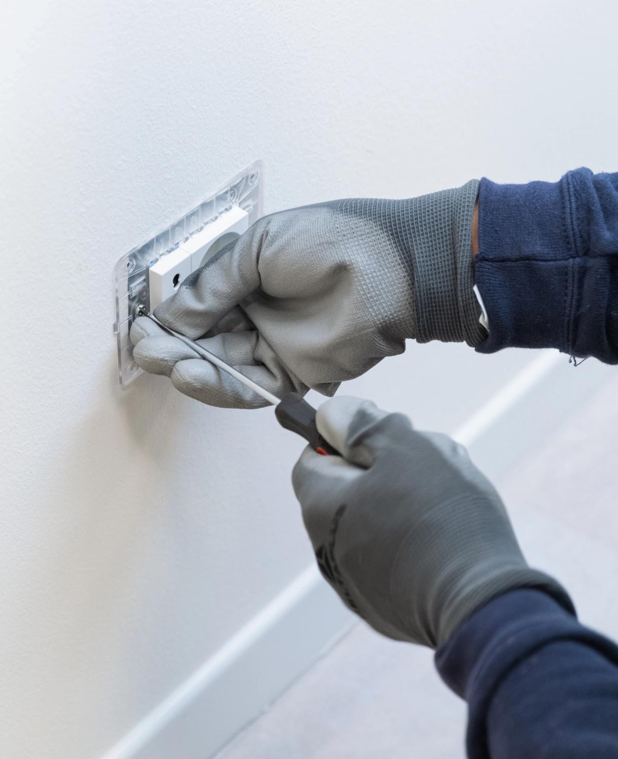 una persona che ripara una presa elettrica