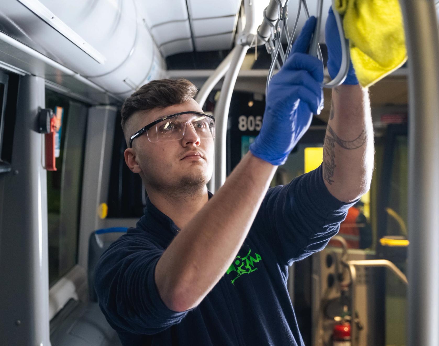 una persona che pulisce un mezzo di trasporto pubblico