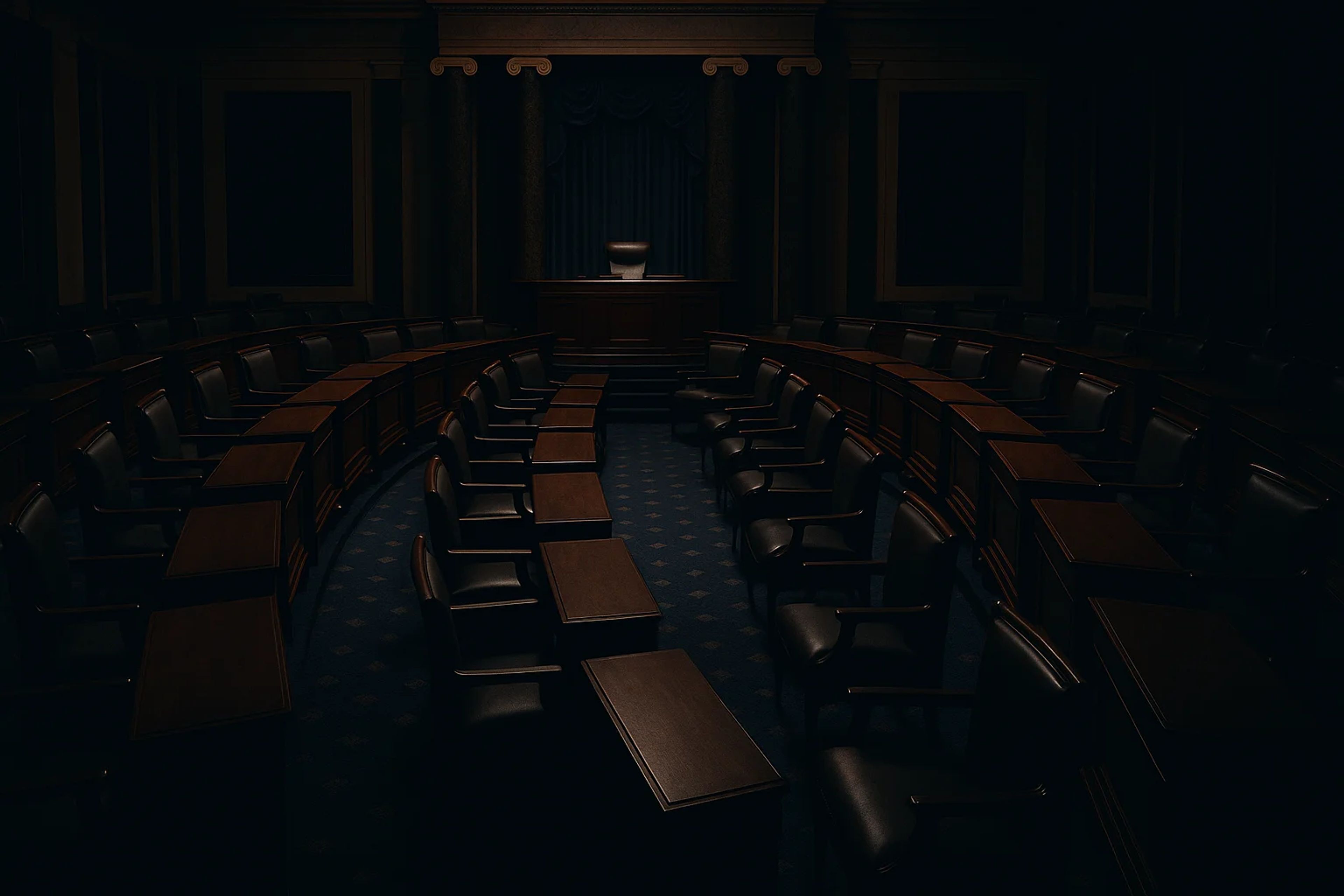 Dimly lit empty legislative chamber with wooden