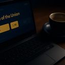 Laptop keyboard with a coffee cup beside it