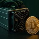 A Bitcoin coin next to a cryptocurrency mining