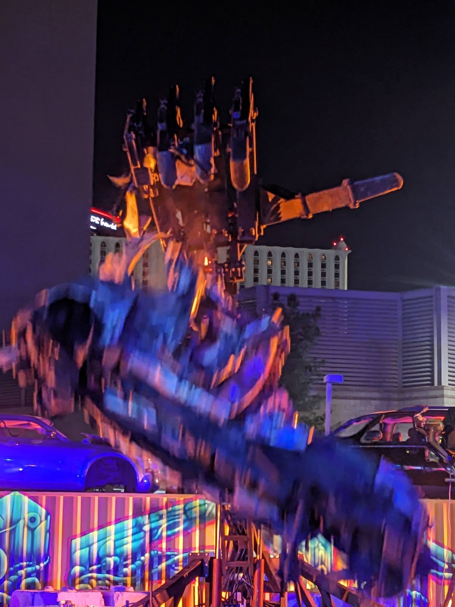 A giant robot hand drops a crushed car