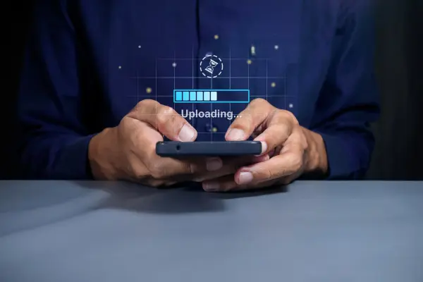 Persona sostiene un smartphone con una barra de progreso de carga superpuesta sobre la pantalla