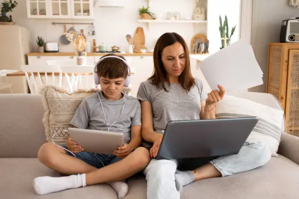 Madre e hijo estudiando en casa con portátil y tablet conectados al WiFi