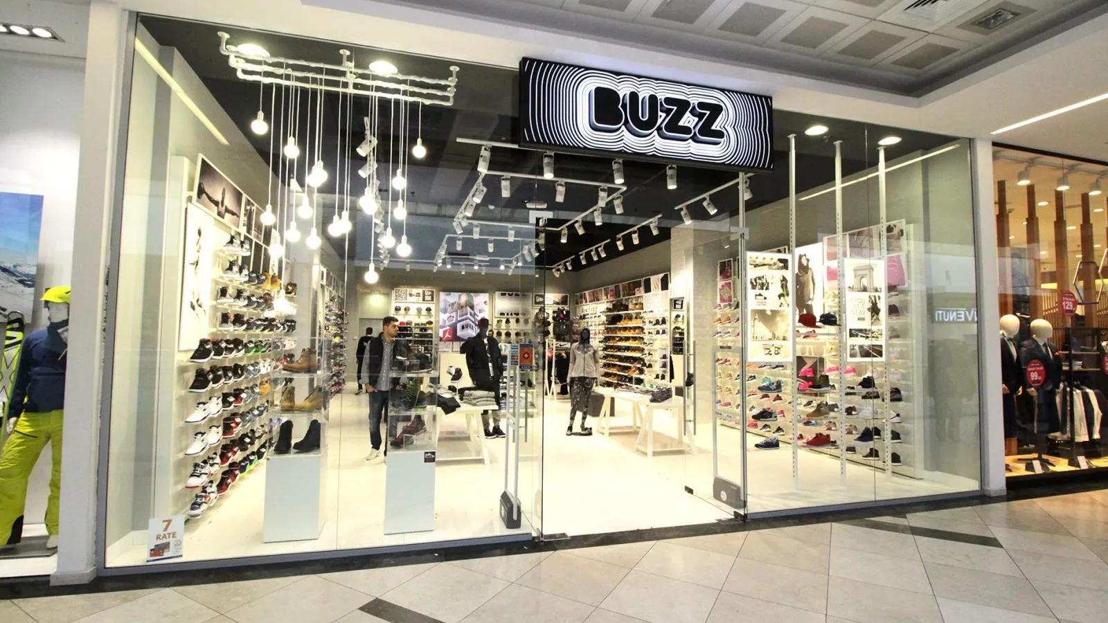 Buzz shoe store in a mall with shoes displayed in its windows.