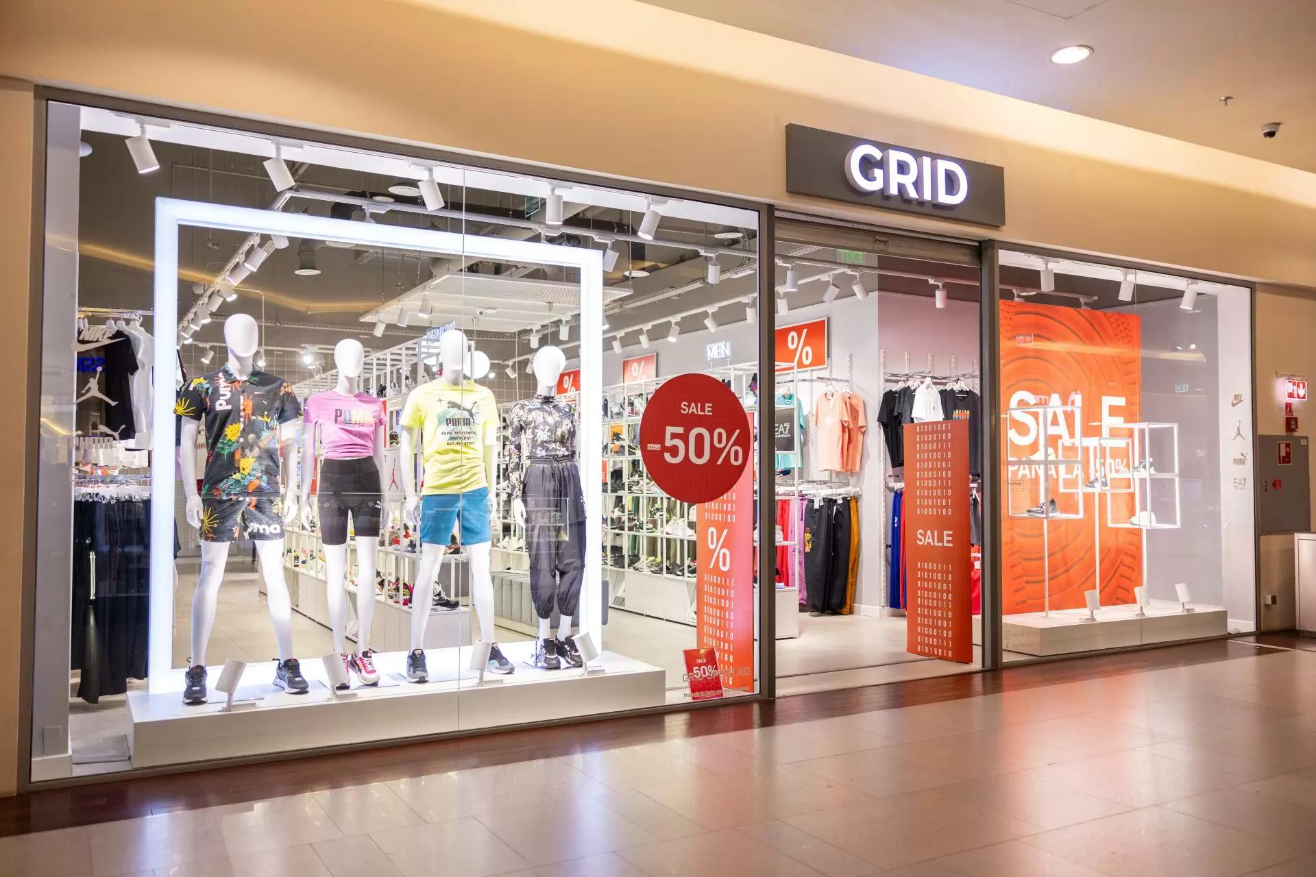 GRID store storefront with activewear mannequins and "SALE -50%" signs.