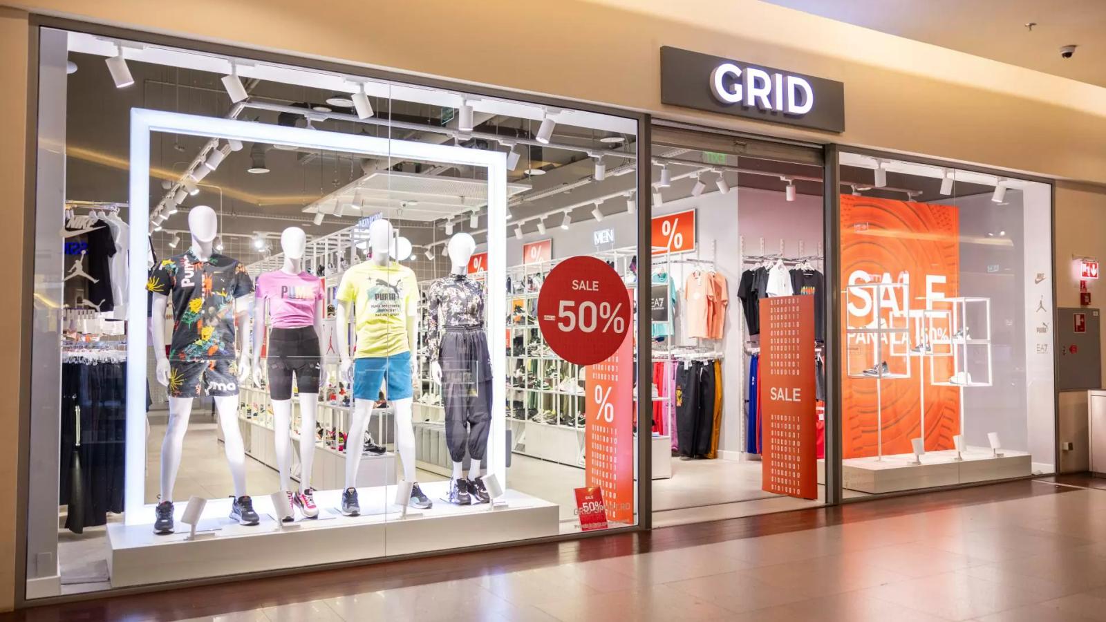 GRID store storefront with activewear mannequins and "SALE -50%" signs.