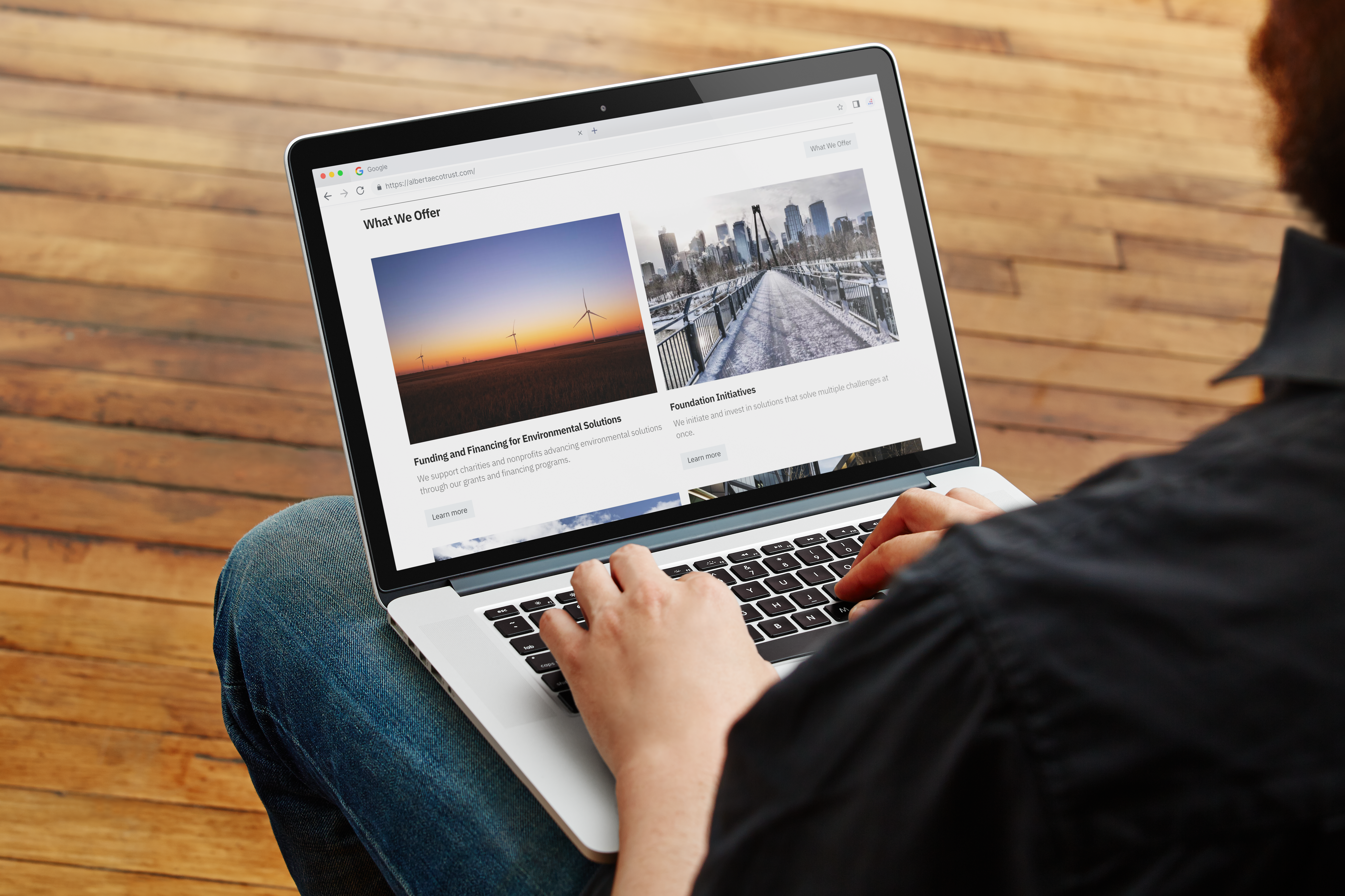 person using a computer scrolling through the Alberta Ecotrust homepage