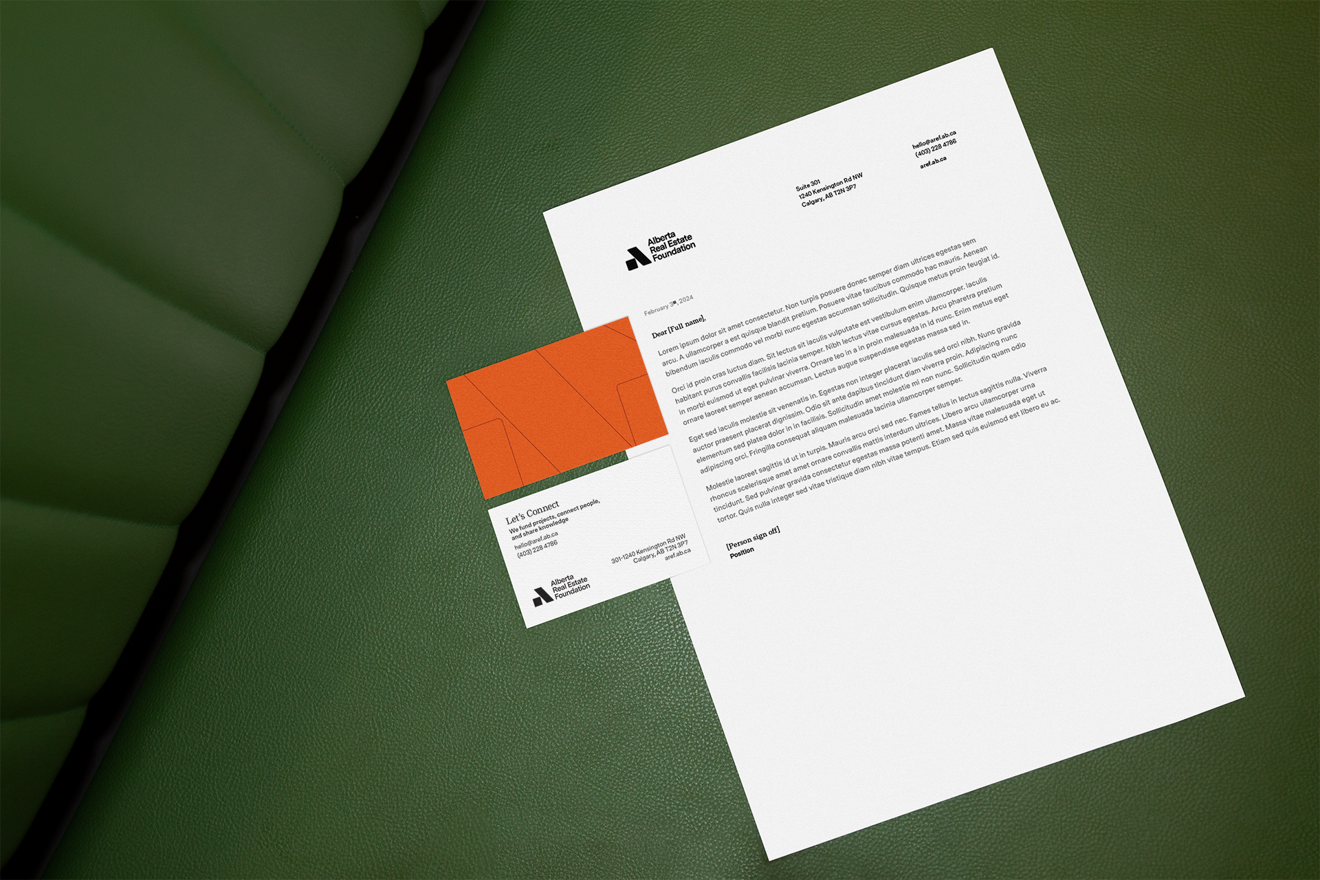 AREF letterhead template and a business card on a green leather sofa.