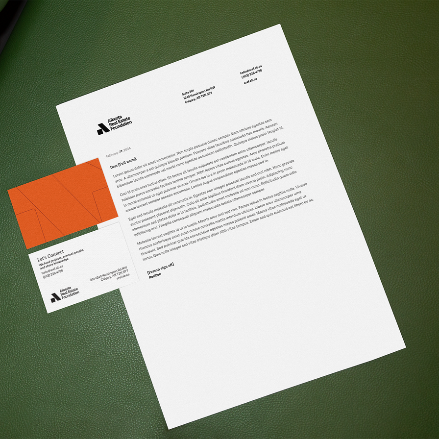 AREF letterhead template and a business card on a green leather sofa.