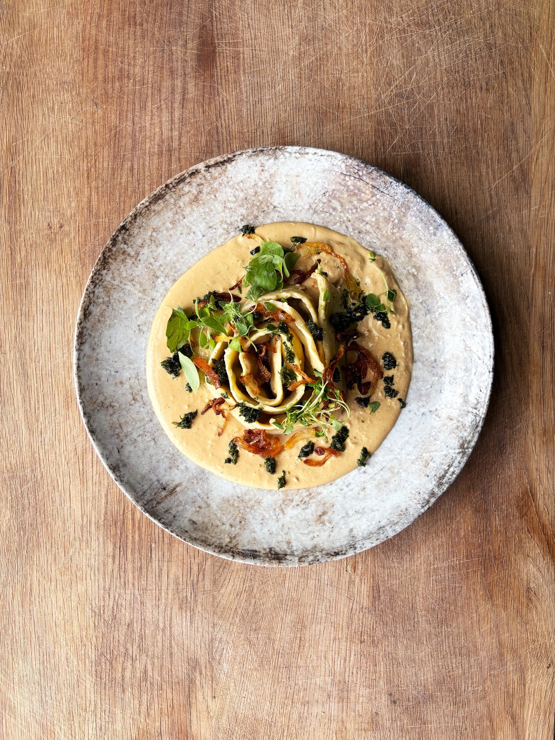 Długa klucha z ricottą, w sosie kurkowym, z ziołami i prażoną cebulką