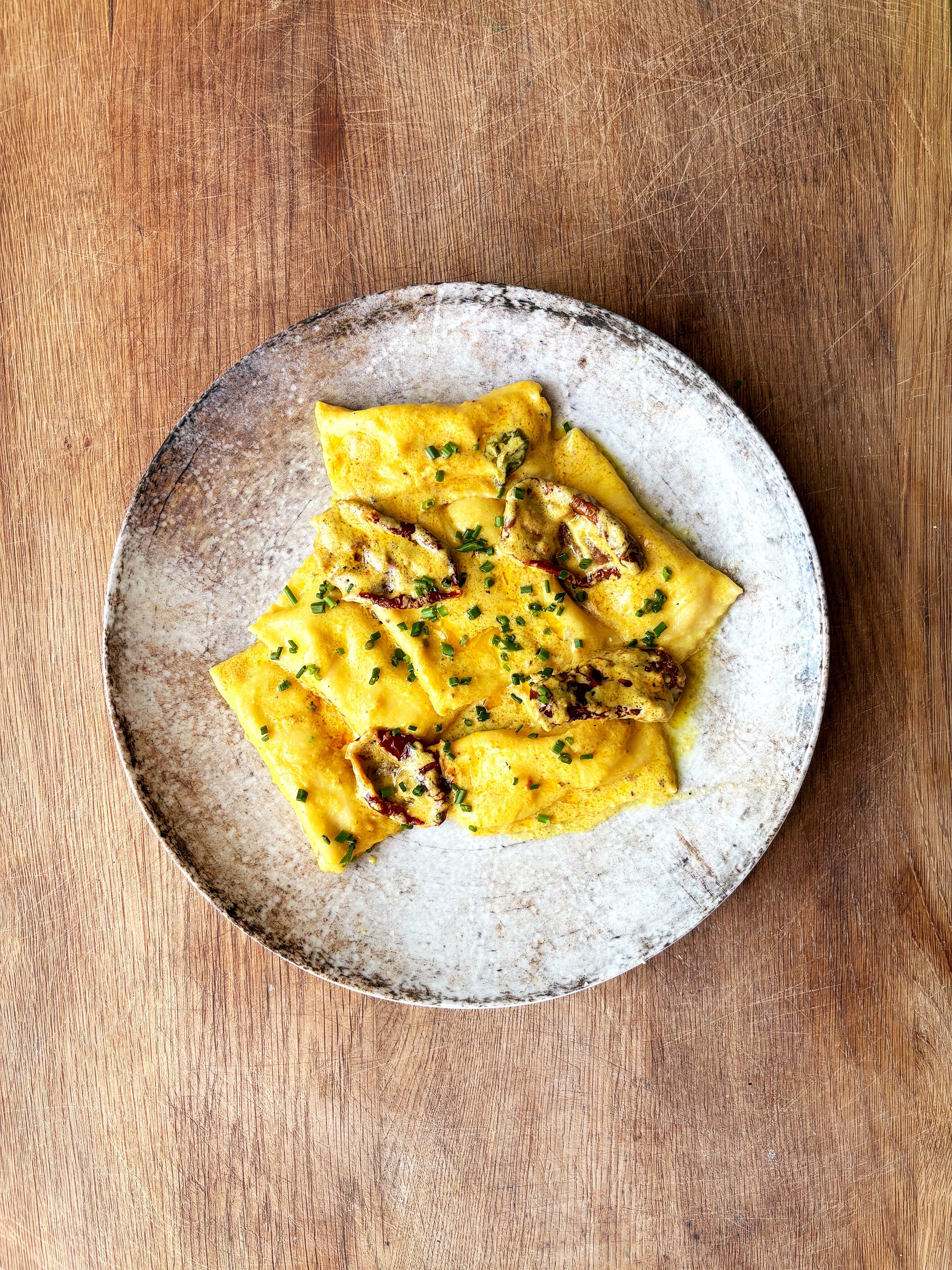 Agnolotti z ricottą w żółtym sosie z pomidorów, kurkumy i krokosza