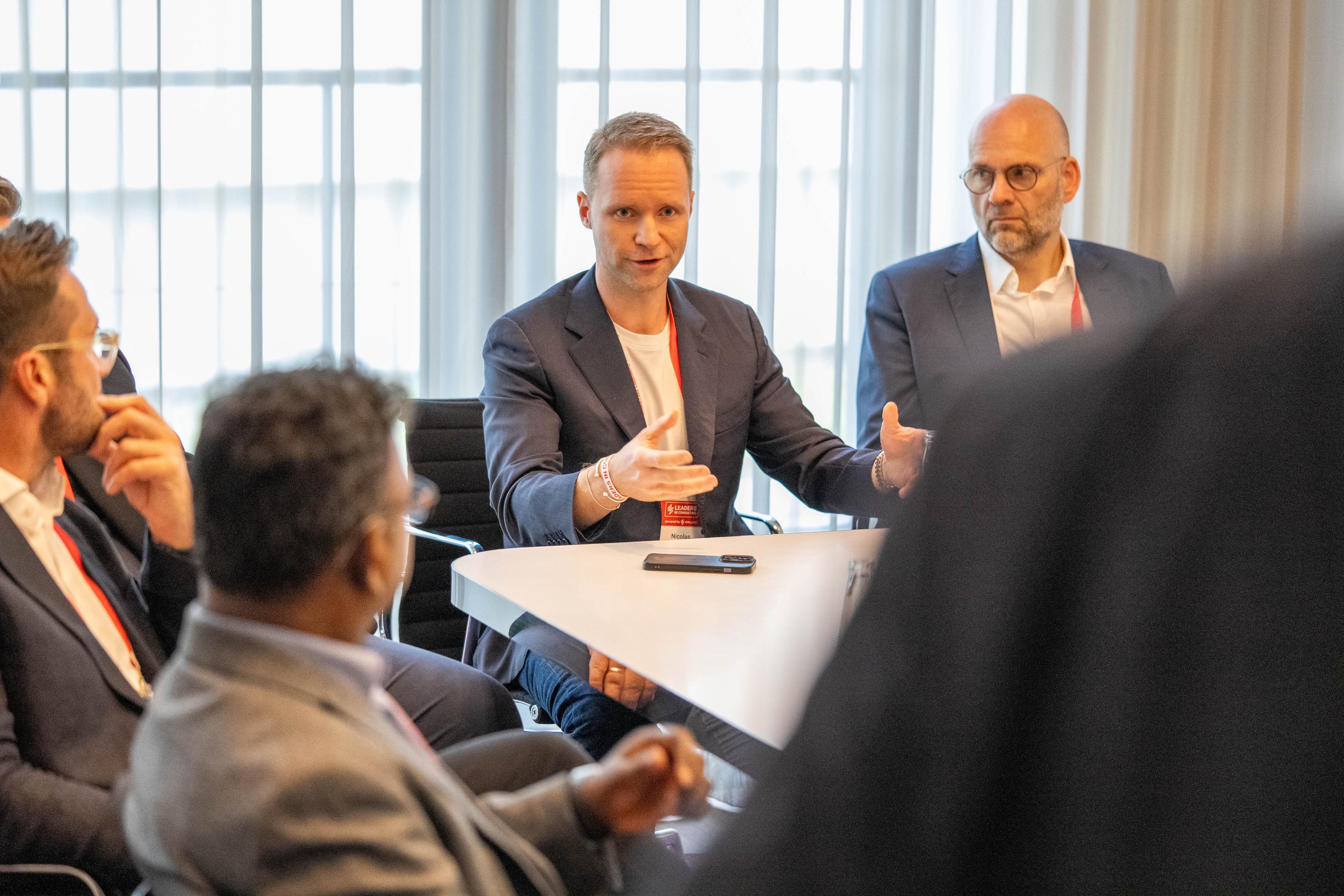 Consulting leaders engaging in a hands-on strategy session at Leaders in Consulting Conference 2025, discussing real-world business growth challenges