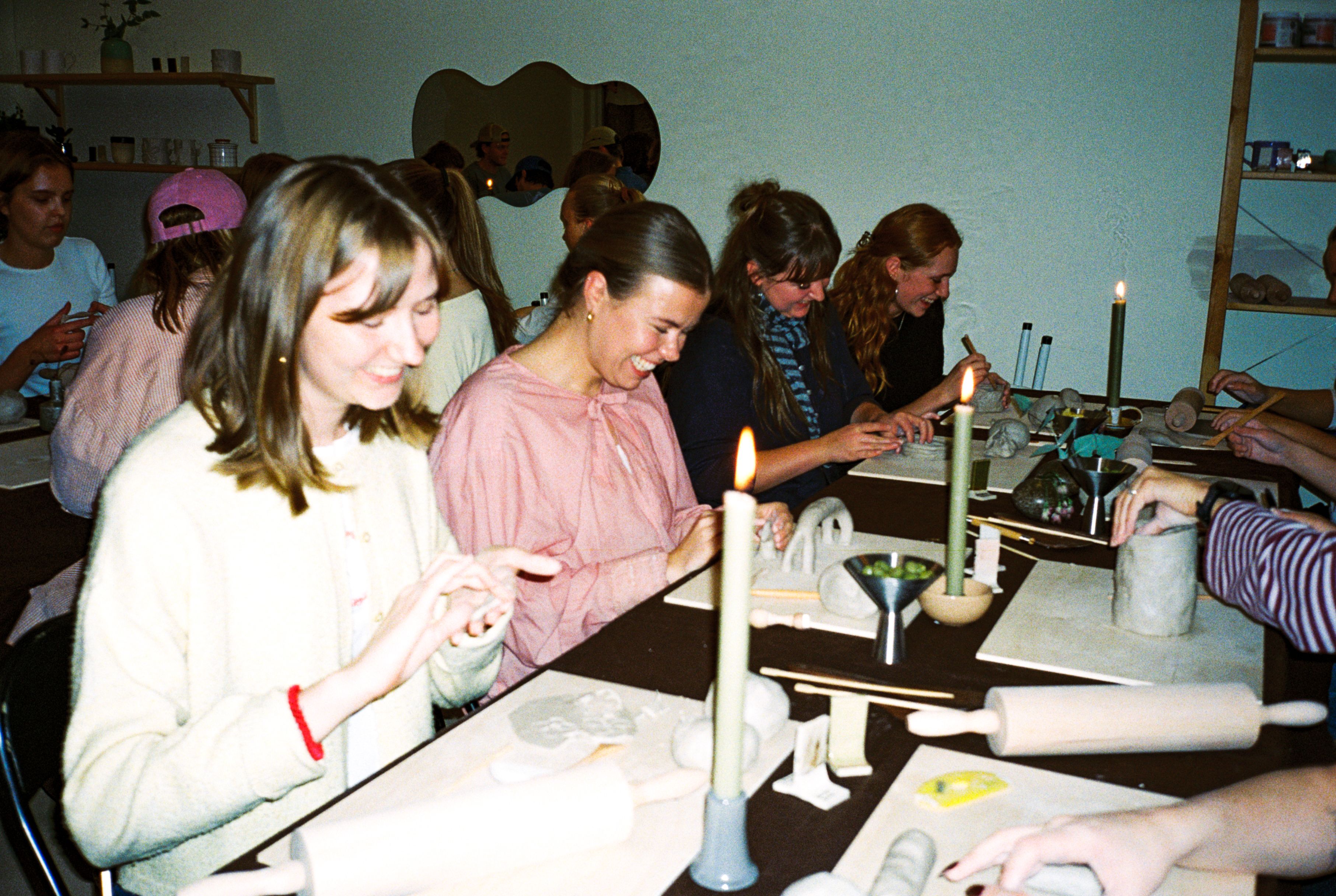 Gjester rundt et langbord i Dreie-studioet med leire, stearinlys og god stemning