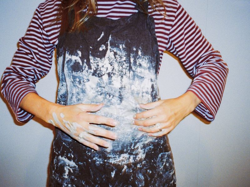 Hender som former en bolle på dreieskiven