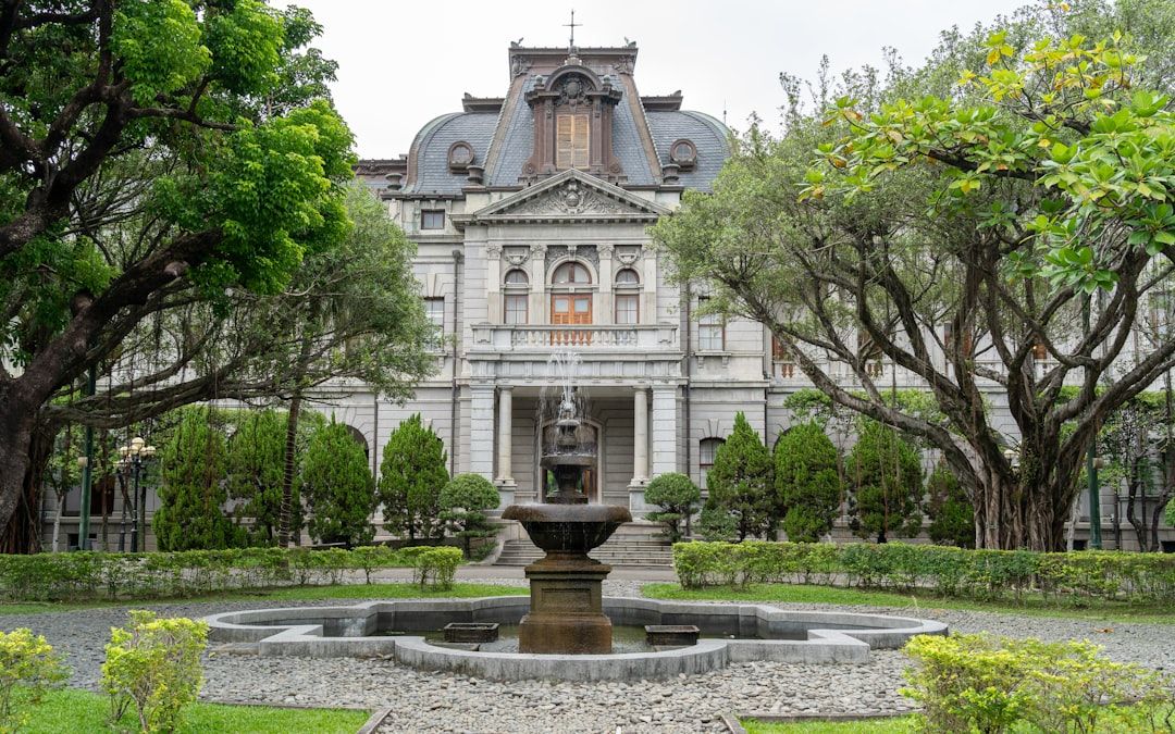 Grand building with a fountain and manicured gardens