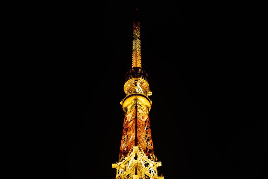 A tall tower illuminated at night against a dark sky