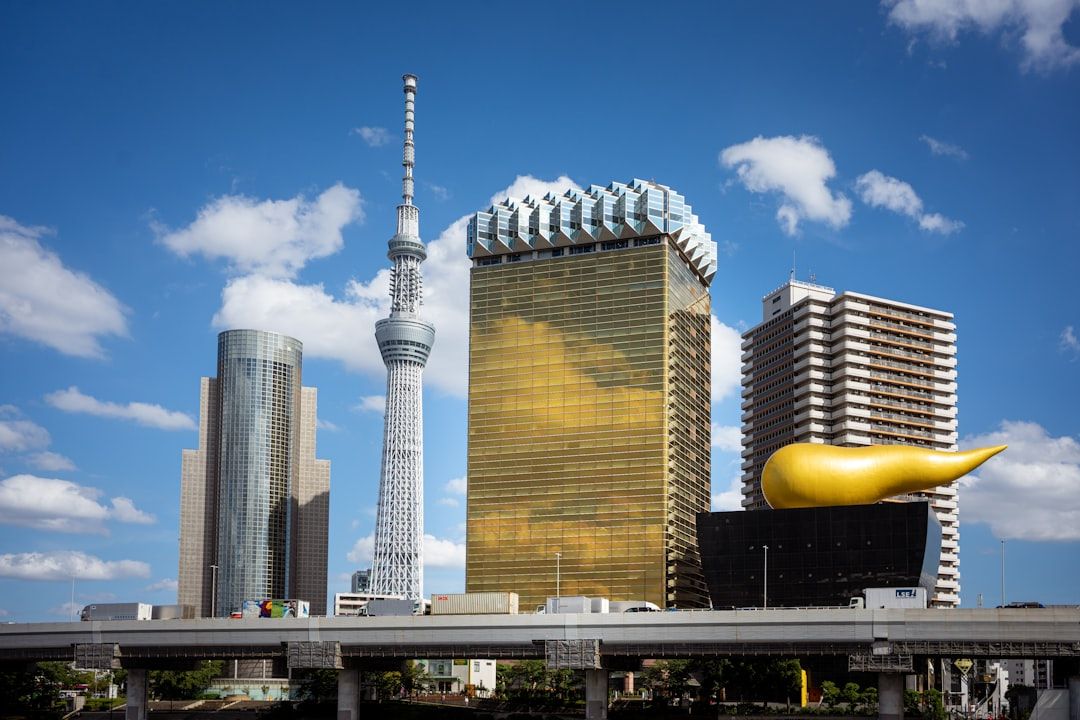 Modern skyscrapers and a golden building under blue sky.