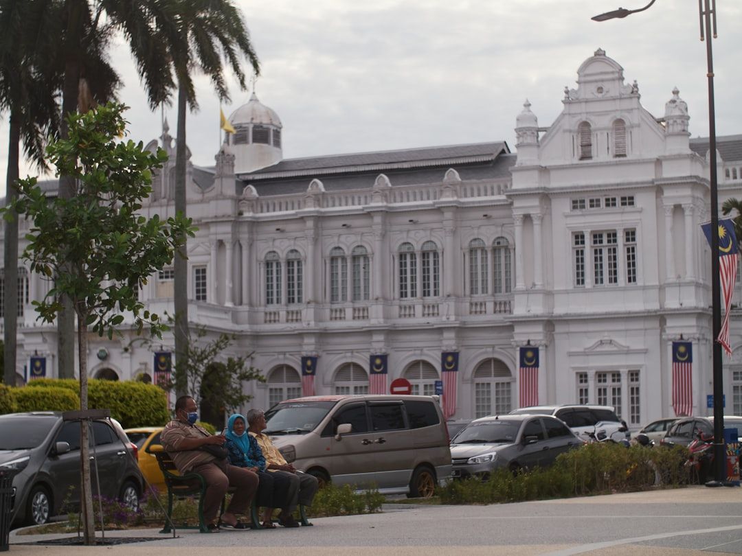 a group of people sitting on a bench in front of a white building